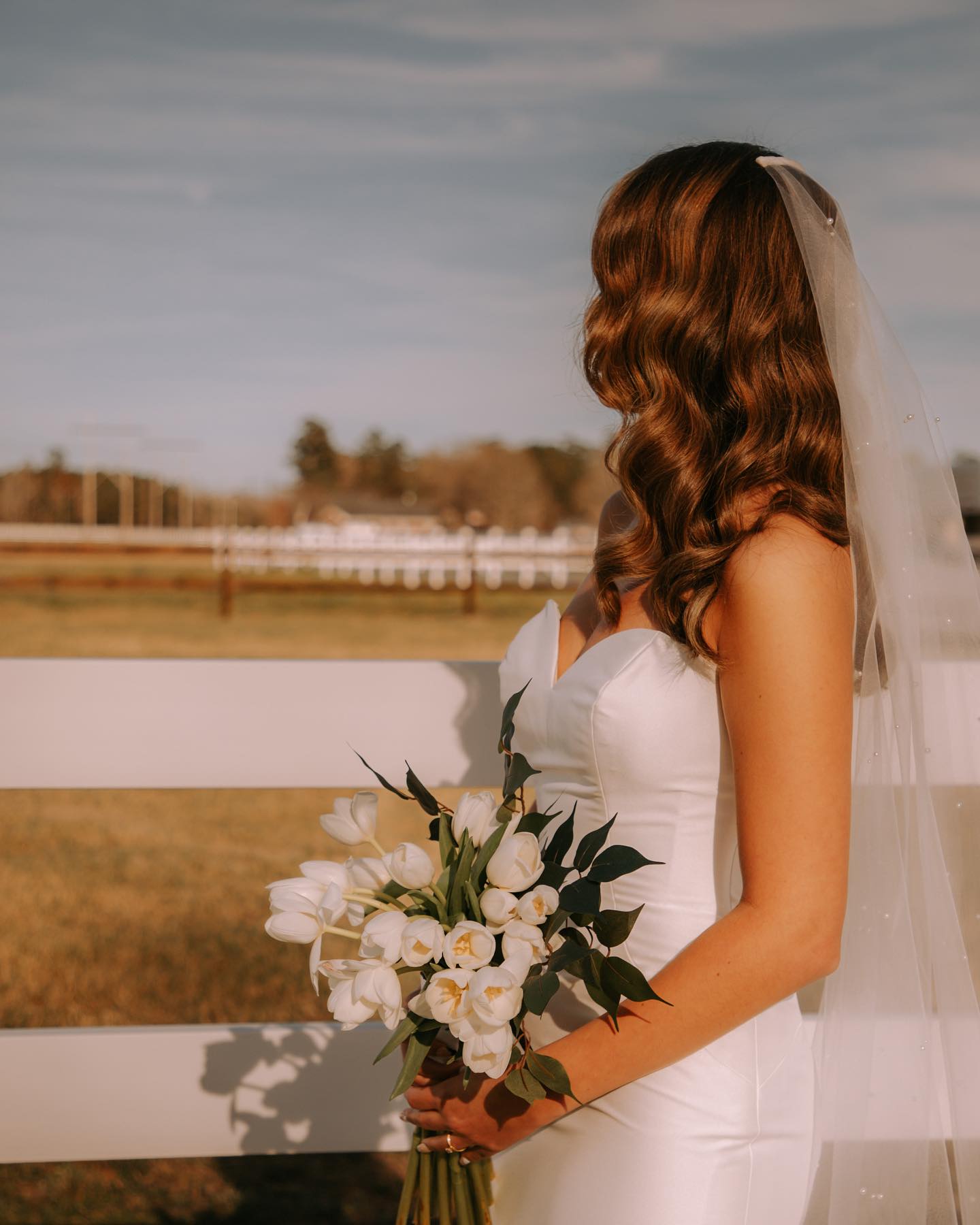 Bride portrait along a rural fence line.